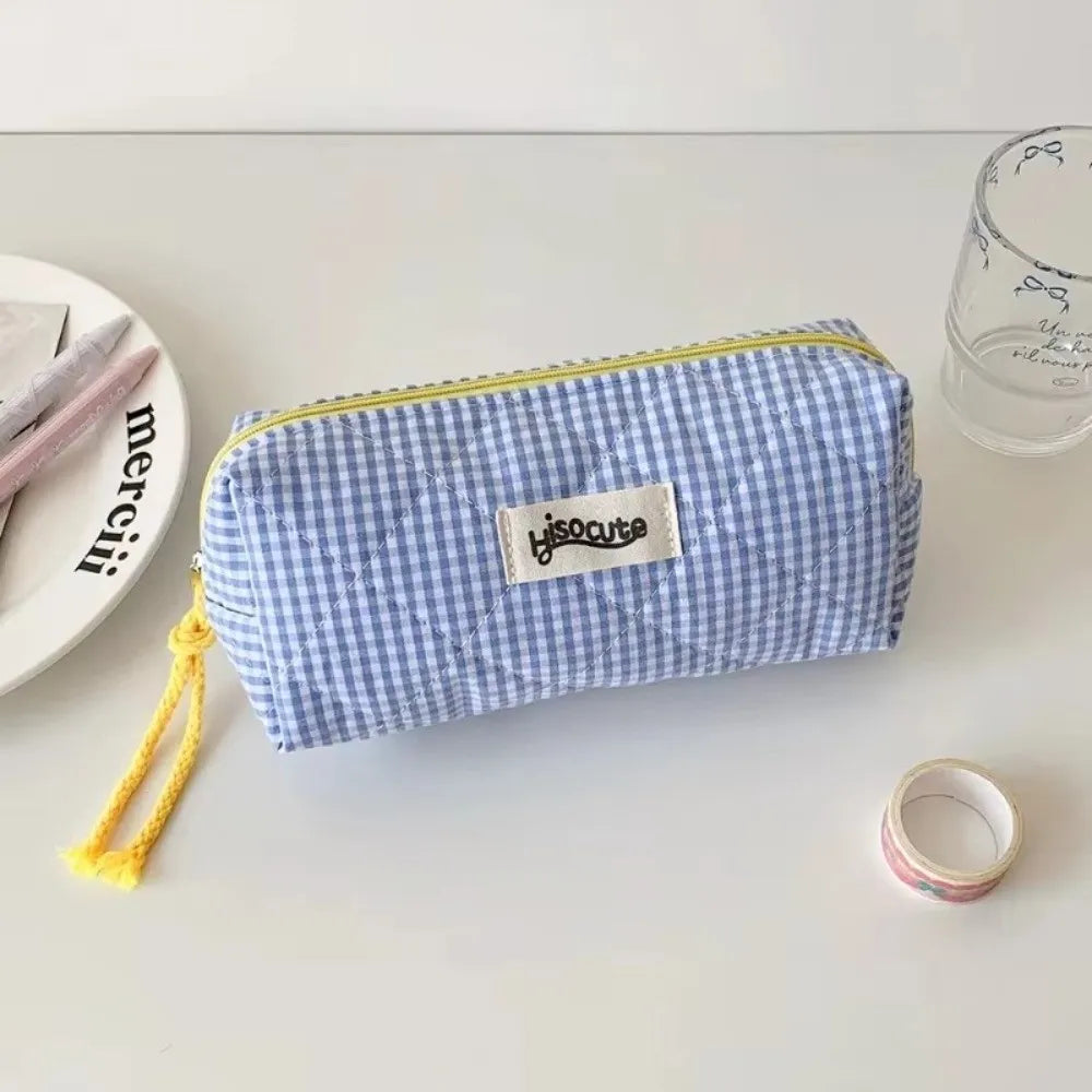 A light blue checkered pencil case with a yellow drawstring is displayed on a white surface.
