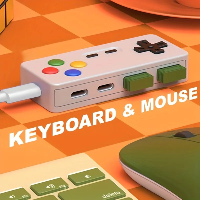 A pink 4-in-1 USB hub with Type-C ports is shown next to a computer keyboard and mouse on an orange checkered surface.