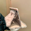 A pink rabbit plush case is shown resting on a light pink iPad, next to a denim jacket.