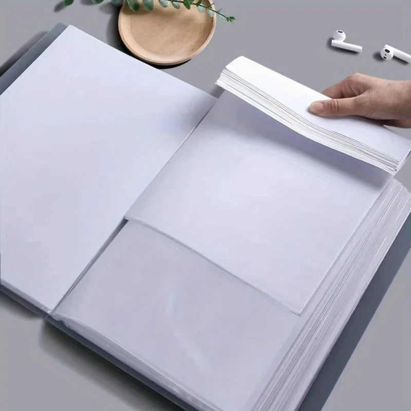Una mano sostiene una carpeta blanca A4 abierta con múltiples bolsillos, demostrando un producto de organización de documento