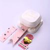 A white crafting tool featuring a tag punch corner rounder and a heart-shaped tag with a February message.
