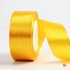 A roll of bright golden satin ribbon used for gift wrapping or DIY crafts.