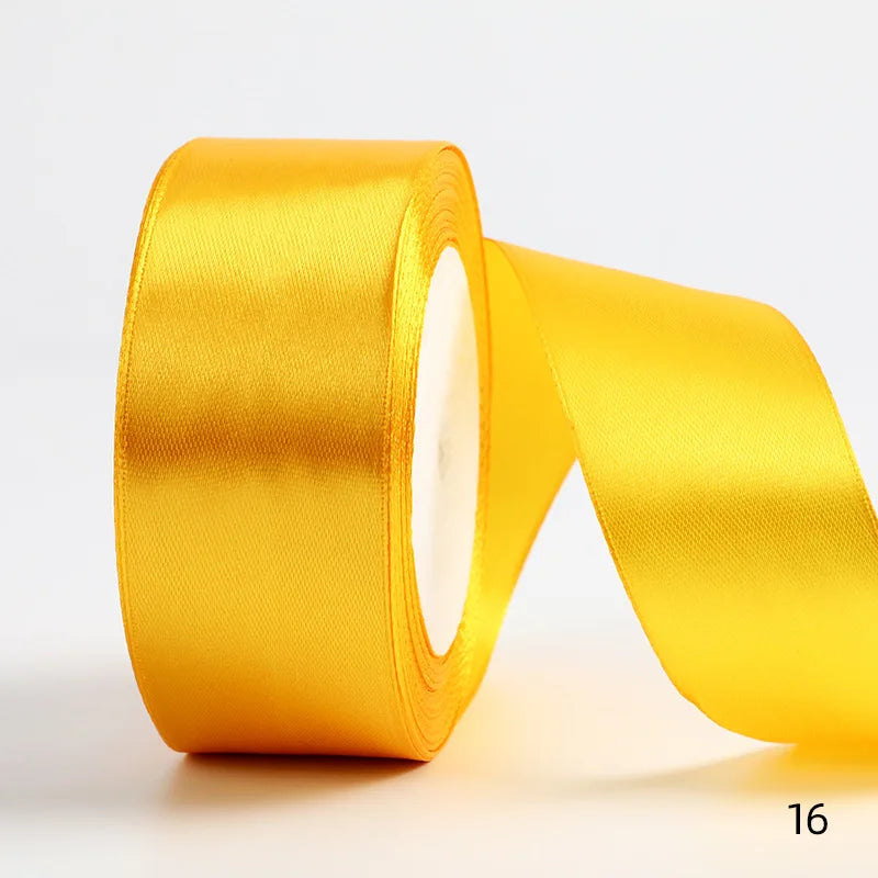A roll of bright golden satin ribbon used for gift wrapping or DIY crafts.