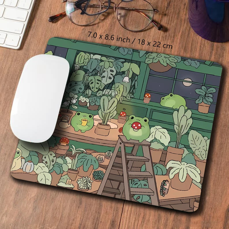 A large desk mat featuring a cute green frog and various plants in a nature-themed design.