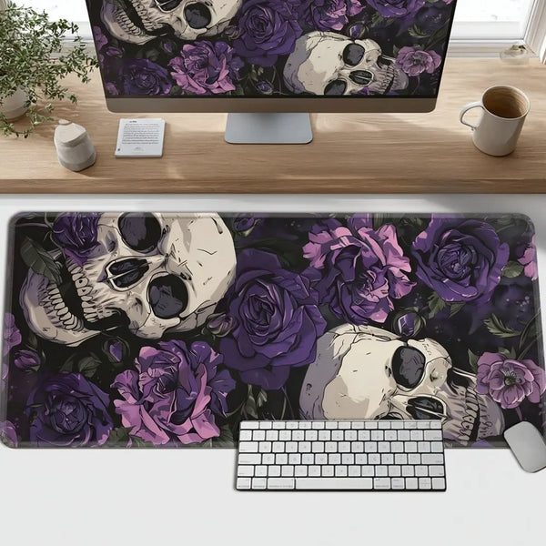 Dunklviolette und schwarze Matten mit gotischen Schädeln und Rosen vor einem Computerbildschirm und einer Tastatur.