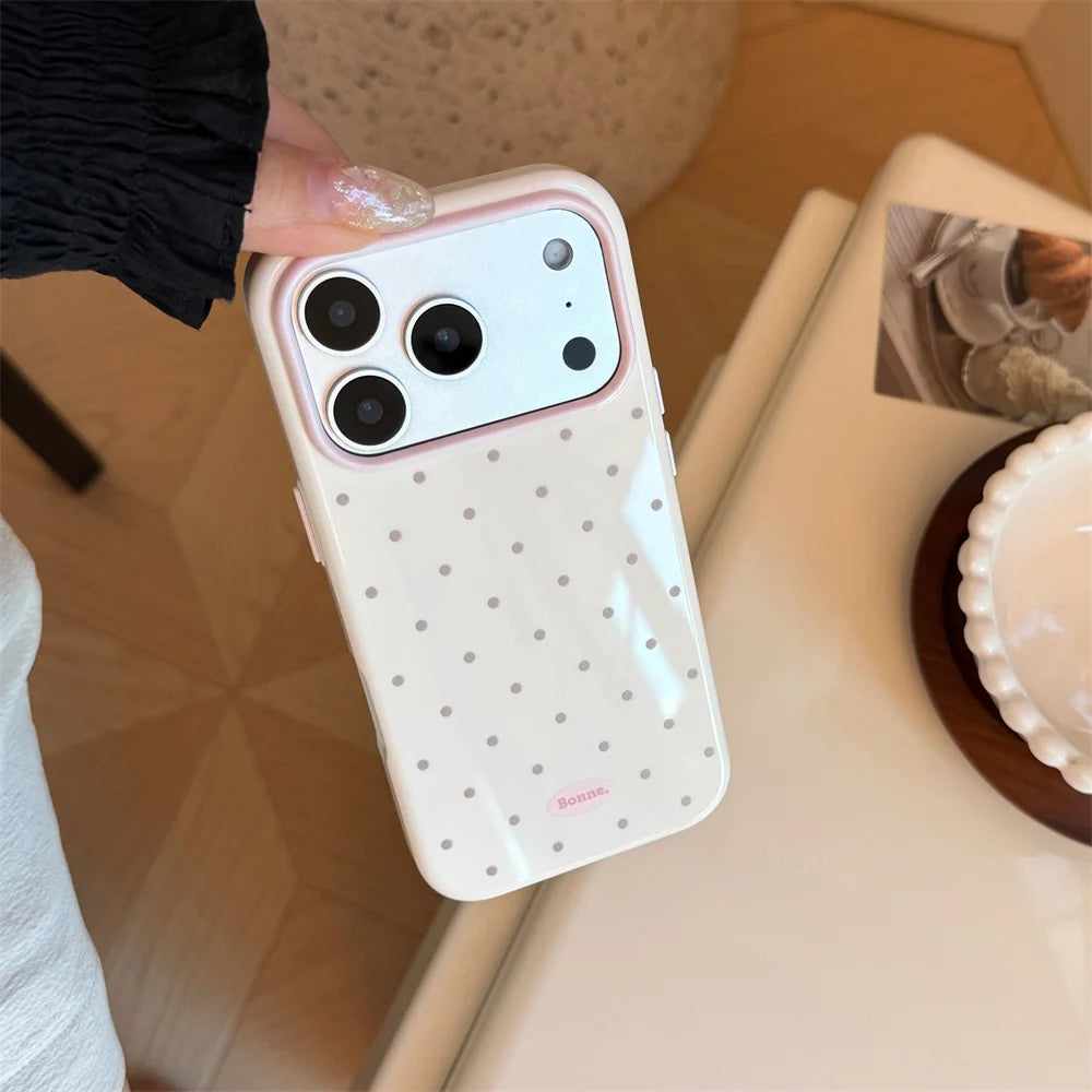 A white candy polka dot shockproof phone case for an iPhone is held in a hand against a light background.