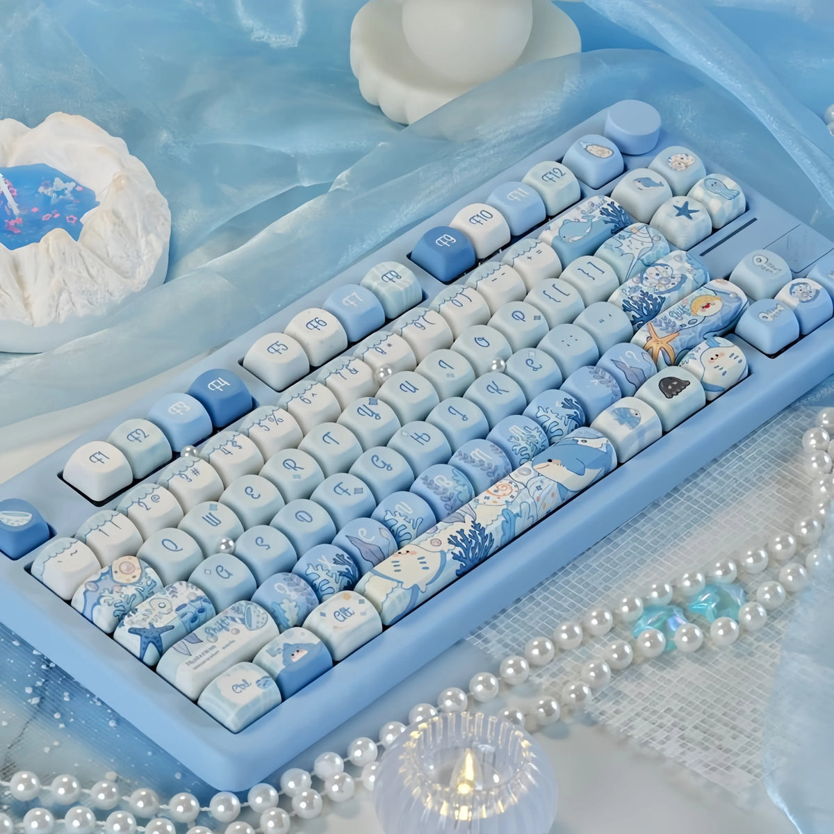 Blue sea themed PBT keycaps for a mechanical keyboard displayed on a light blue surface.