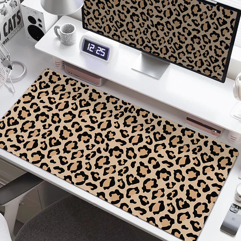 A large leopard print desk pad featuring brown and black spots is displayed on a white desk.