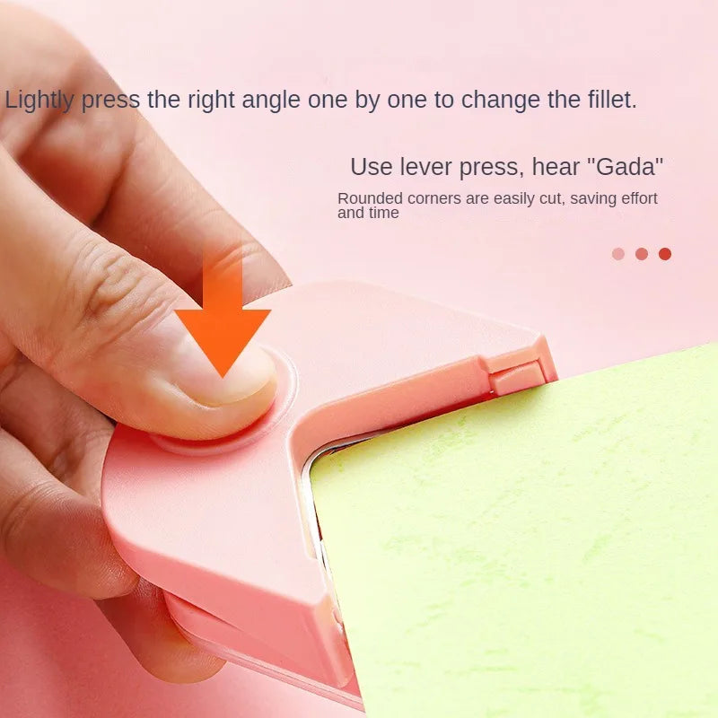 Eine Hand drückt ein rosa Präzisionswerkzeug zum Abrunden einer Ecke auf hellgrünes Papier.