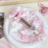 A pink and white decorative plate featuring an intricate cat claw angel wing art knife cutter with pearl accents.