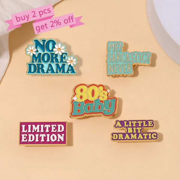 A set of enamel pins featuring phrases like No More Drama, Ever Sarcastic, 80s Baby, Limited Edition, and A Little Bit Dramat