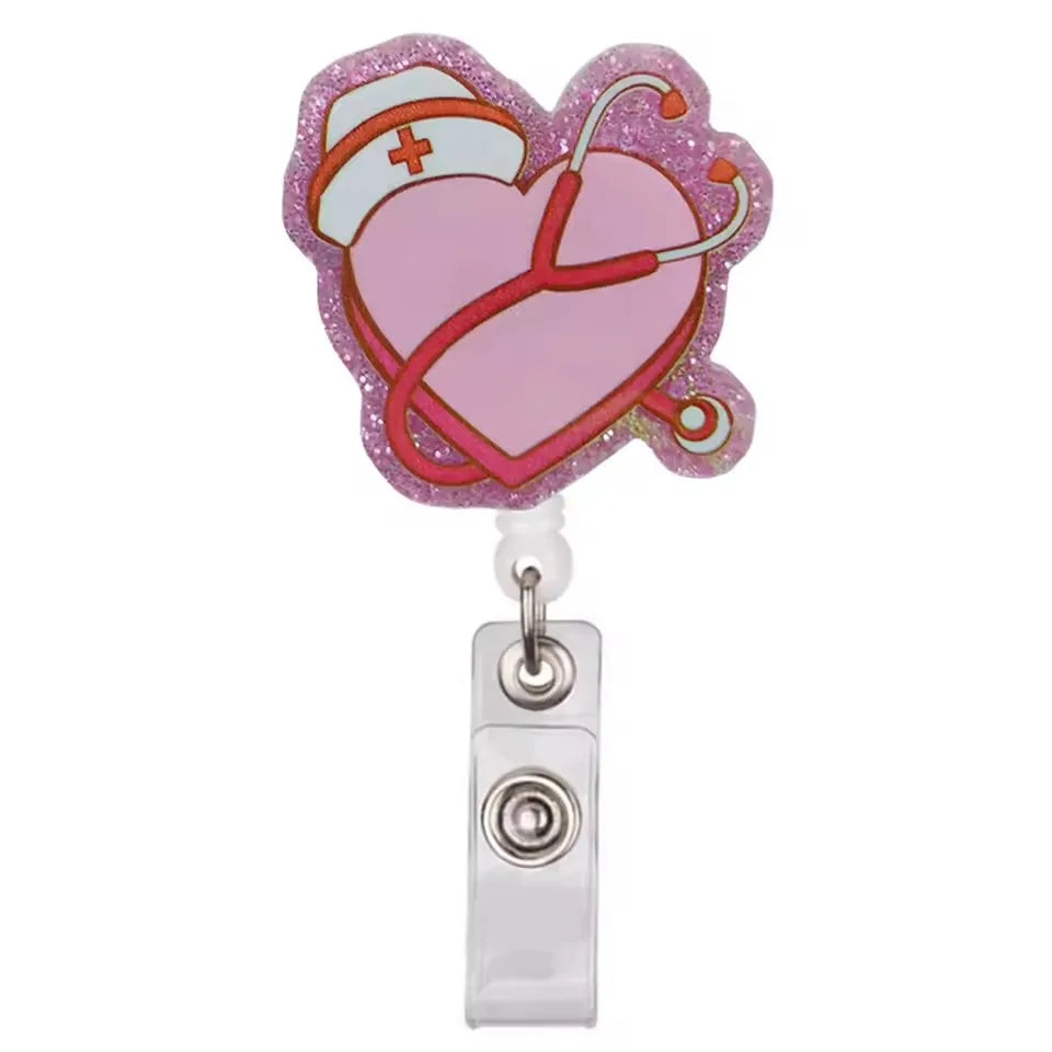 A pink heart-shaped badge reel holder with a stethoscope design and a silver clip.