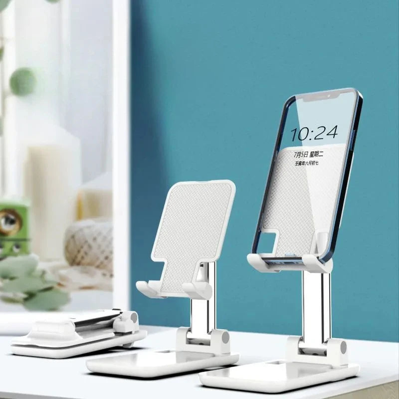 A white foldable desktop phone stand is shown next to a smartphone on a white surface.