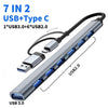 A silver multiport hub featuring seven ports including USB 3.0, USB 2.0, and Type-C connectors.