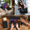 A black detachable wireless keyboard folio case for an iPad is shown open on a wooden desk with a laptop and accessories.