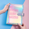 Eine Hand hält einen glänzenden rosa Umschlag mit der Aufschrift "100 Envelope Savings Challenge" vor einem blau-rosa Hinterg