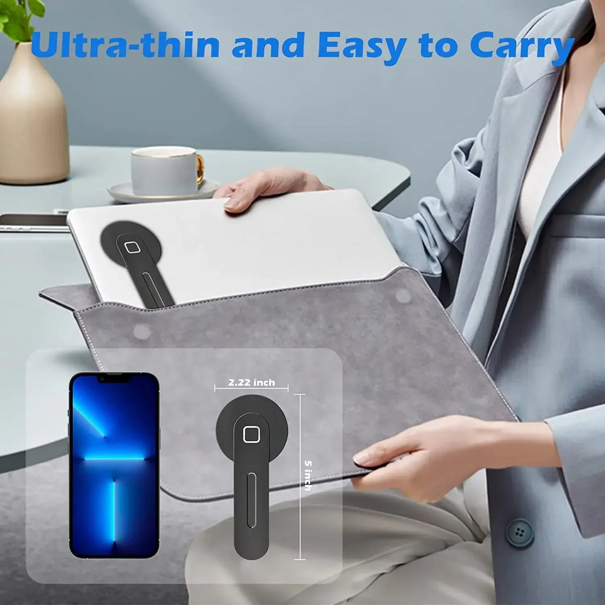 A hand holds a gray magnetic phone holder designed for use with a laptop or monitor.