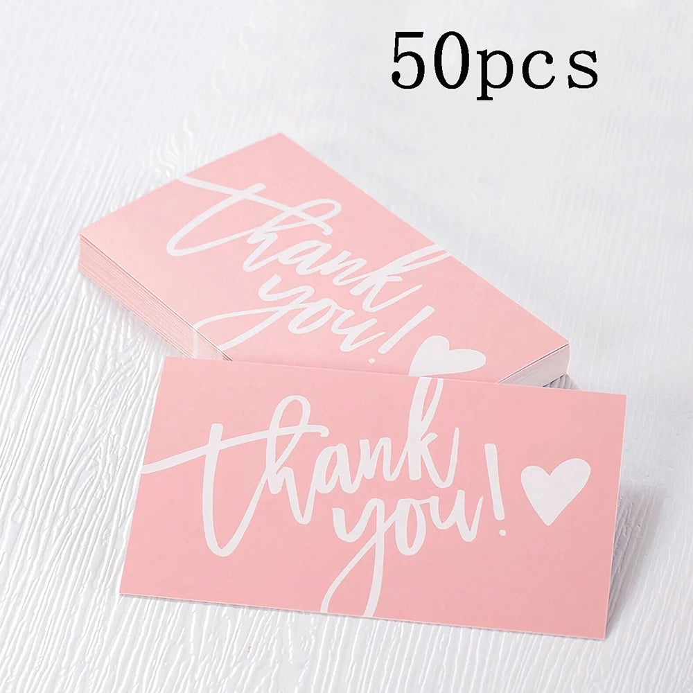 A stack of 50 pink thank you cards with white script text on a white background.