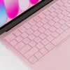 A close-up of a pink silicone keyboard cover for a MacBook, showing the keys and part of the laptop body.