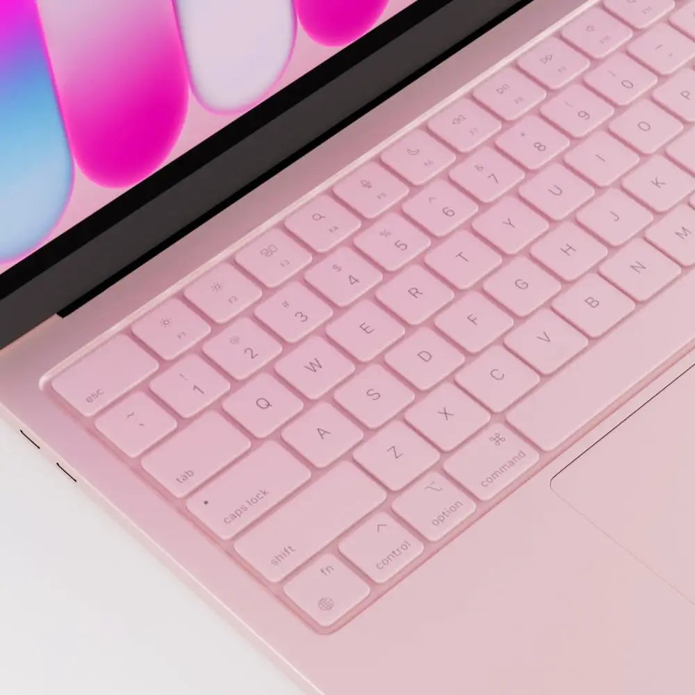 A close-up of a pink silicone keyboard cover for a MacBook, showing the keys and part of the laptop body.