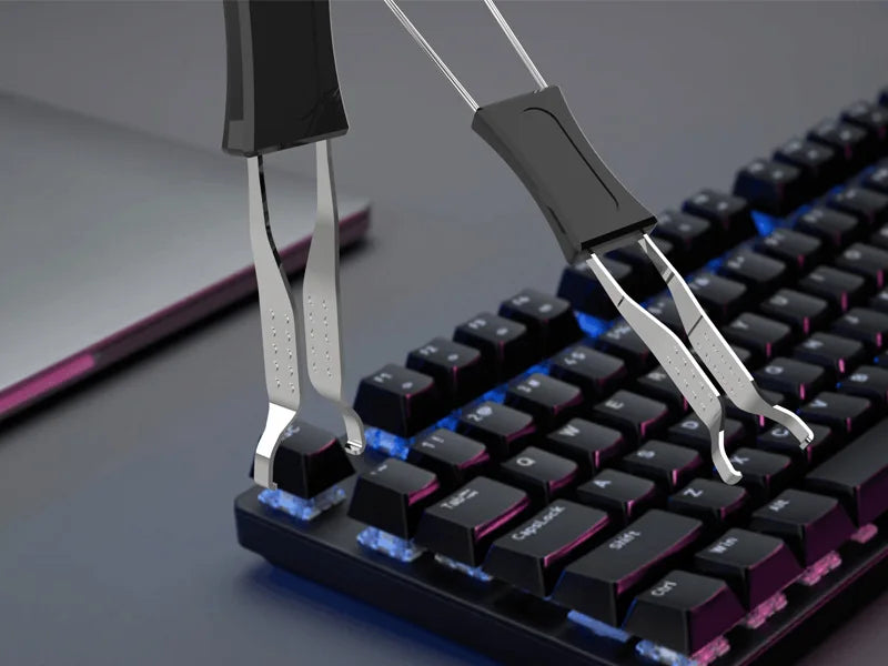 Primer plano de una mano usando un extractor de keycaps plateado para quitar una tecla de un teclado mecánico negro.