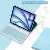 Funda de iPad azul claro con teclado Bluetooth desmontable, abierta sobre una superficie de mármol blanco.