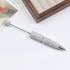 A silver pen accessory featuring a rhinestone ball on the tip and a sparkly, textured body.
