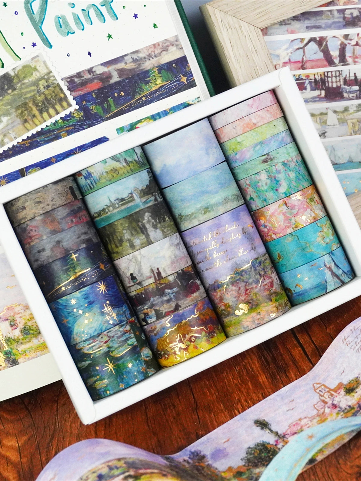A set of oil painting themed decorative washi tape rolls in a white box, featuring various landscape and abstract colors.