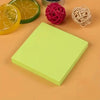 A stack of vibrant neon self-adhesive sticky notes next to citrus slices and red string