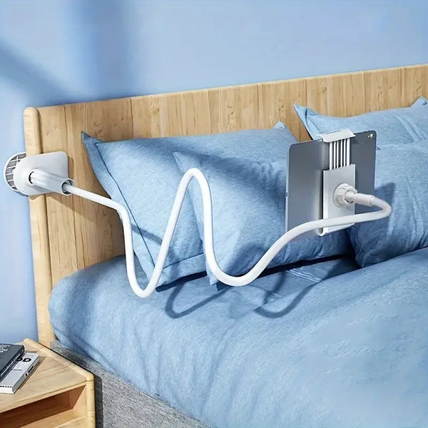 A blue fabric pillow is resting on a bed, with a white flexible stand attached to it.