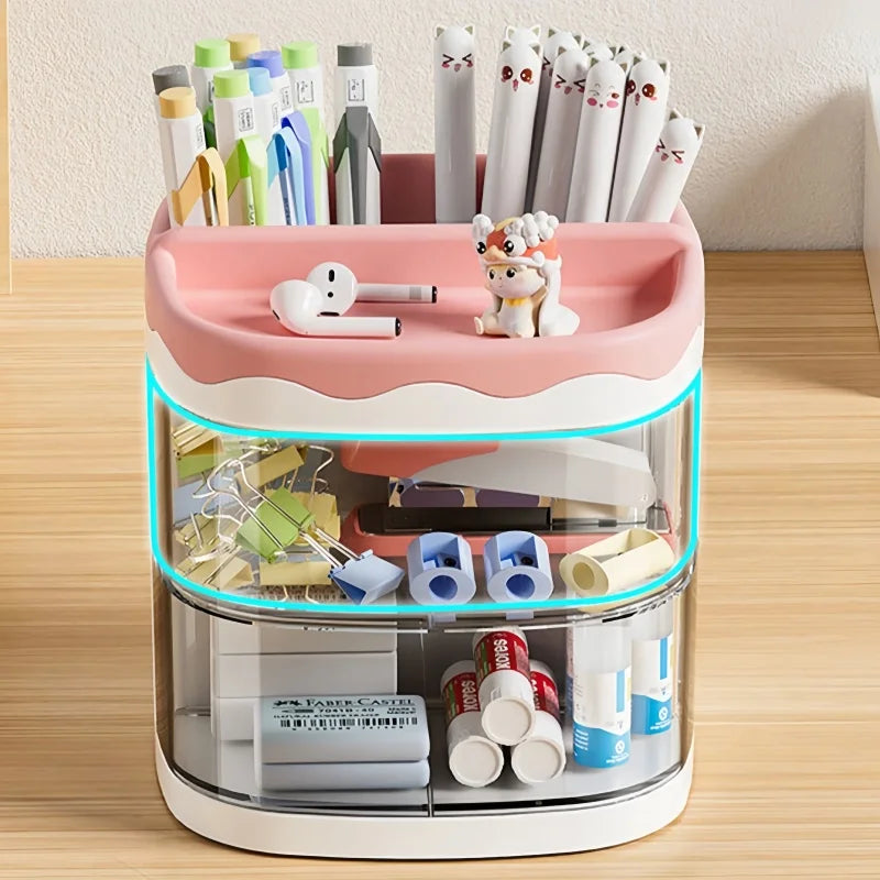 A pink desktop pen holder with a clear top section displaying various pens, pencils, and stationery items.