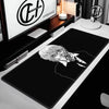 A black gaming mouse pad featuring a white line art drawing of an anime character's face.