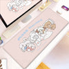 A pink cartoon gaming desk mat featuring a group of fluffy white and brown rabbits.