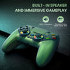 A green RGB wireless gaming controller is shown on a dark surface with text highlighting built-in speakers and immersive game