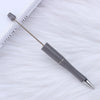 A silver DIY beadable pen with a purple tip rests on a white surface.