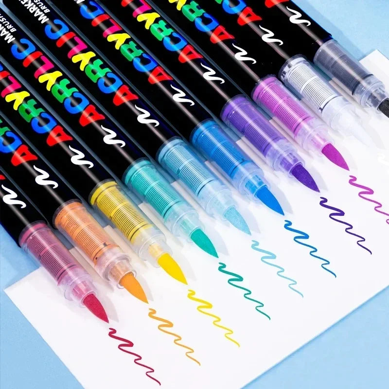 A collection of black acrylic paint markers in various bright colors, laid out on white paper.