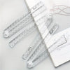 A set of precision acrylic folding rulers and measuring tools laid out on a white background.