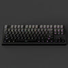 A close-up view of a black mechanical keyboard with gradient gray double shot PBT keycaps and side printing.