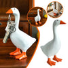 A white resin duck figurine with orange feet is shown next to a magnetic key holder and desk organizer.