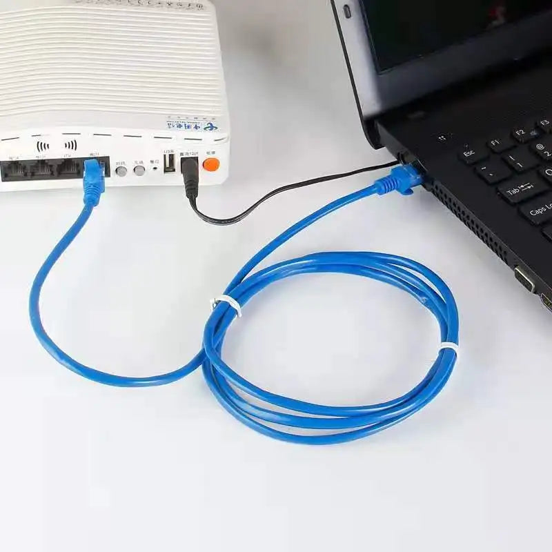 Un cable Ethernet plano azul con conectores RJ45 enchufado a un dispositivo.