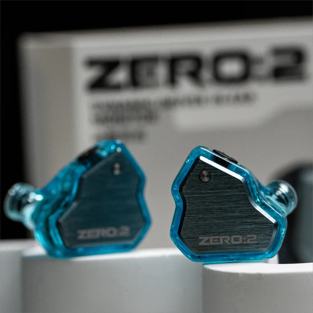 A pair of blue transparent in-ear monitors labeled ZERO:2 resting on a white surface.