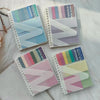 A set of colorful A6 sticky note notebooks with loop closures and various pastel colored stickers.