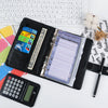 Un set d'organisateur de budget et de liquide noir avec une feuille, une calculatrice et un stylo sur un fond blanc.