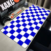 A blue and white checkered desk mat is placed on a wooden desk next to a computer keyboard and mouse.