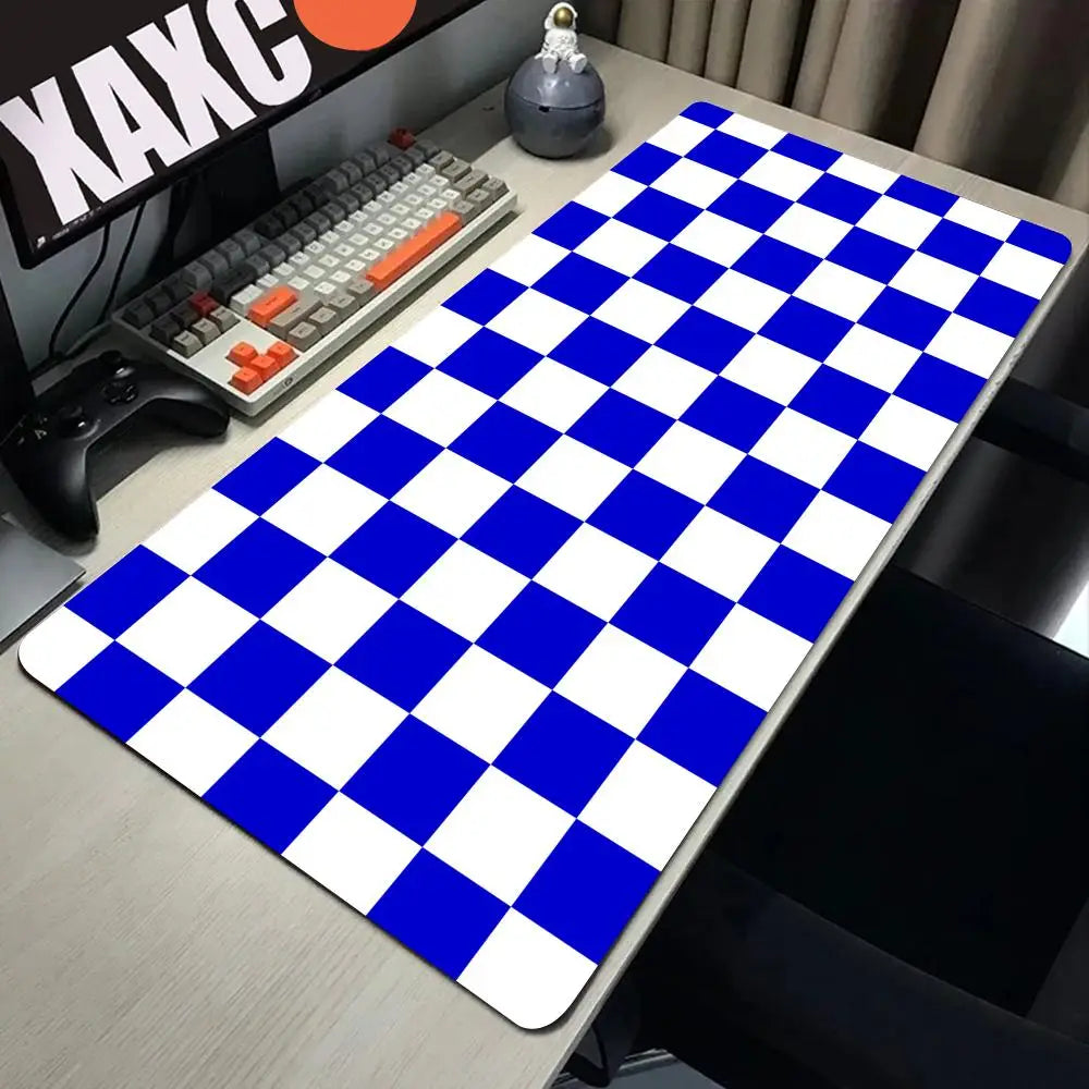 A blue and white checkered desk mat is placed on a wooden desk next to a computer keyboard and mouse.