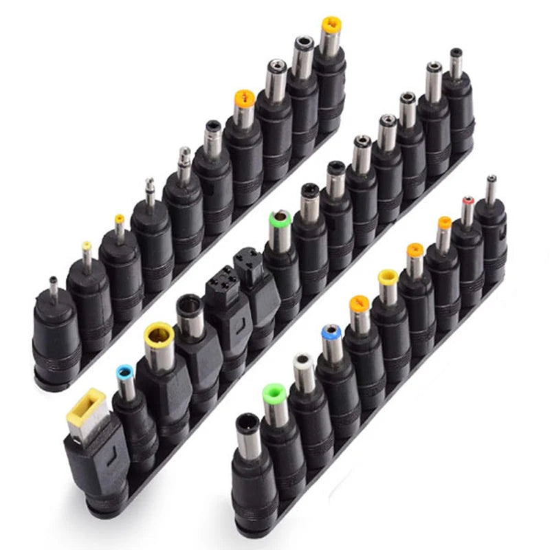 A row of 34 universal laptop charger connector tips in various sizes and colors arranged diagonally.