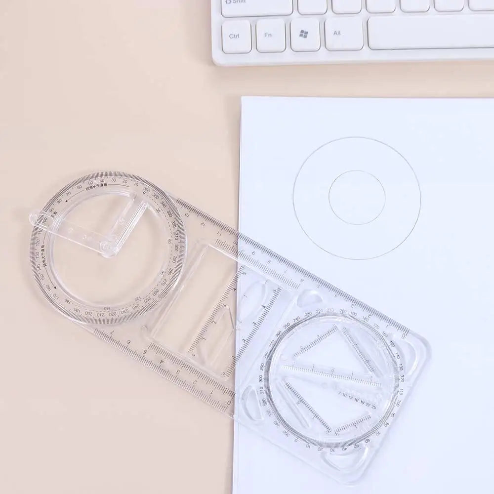 A clear plastic geometric drawing ruler with rotating angles is shown on a white background next to a keyboard.