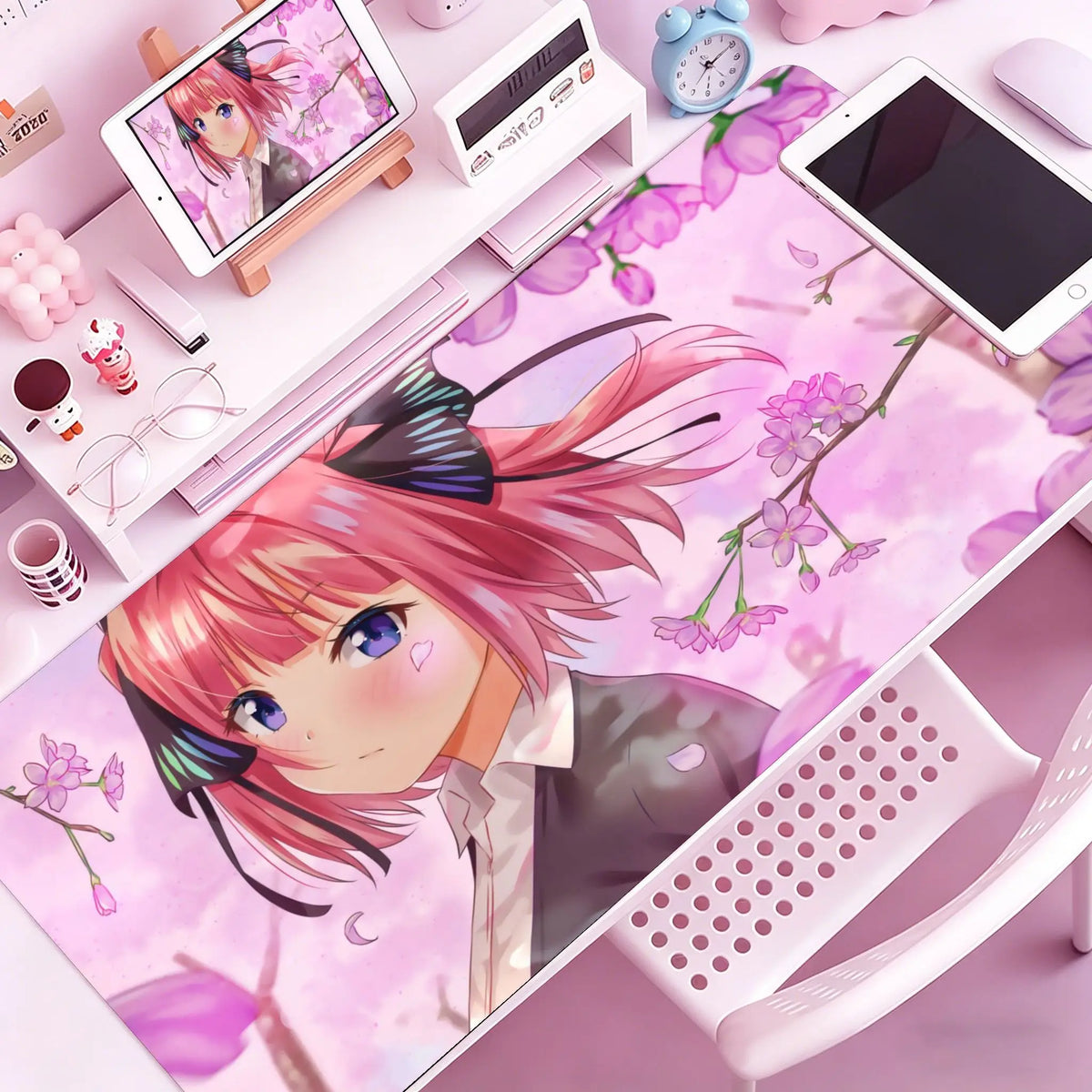 A vibrant illustration of an anime girl with pink hair and purple accents on a pink desk mat next to a computer setup.