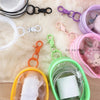 A collection of mini clear bags and colorful keychains displayed on a fluffy surface.