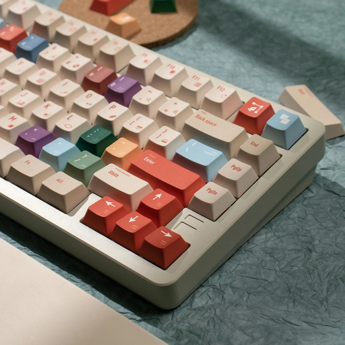 A close-up view of a retro AI illustrator PBT keycap set with various colored keycaps resting on a light surface.